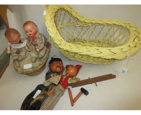 Mid 20th Century automaton group of two celluloid dolls in a wicker basket together with a quantity of puppets and a wicker d