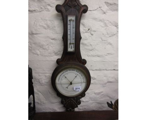 Early 20th Century carved oak aneroid barometer thermometer together with an octagonal mahogany pedestal table with tripod