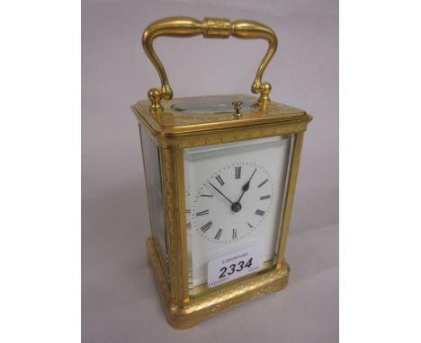 Small late 19th or early 20th Century gilt brass cased carriage clock with engraved floral and fruit decoration, the enamel d