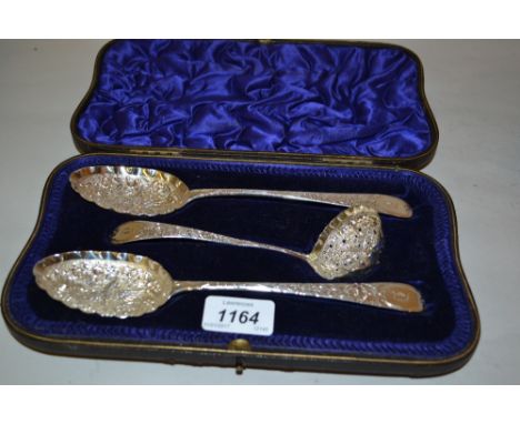 Cased pair of silver Old English pattern berry spoons decorated with flowers and birds, together with a similar ladle