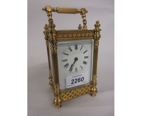Small Edwardian gilt brass cased carriage clock with fretwork decoration and reeded corner pilasters, the enamel dial with Ro