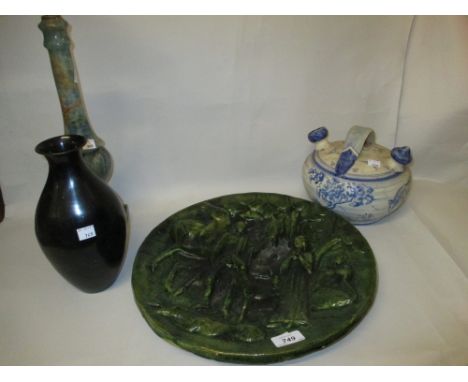 Continental terracotta green glazed charger decorated in high relief with figures and animals in a woodland, an onyx lamp bas