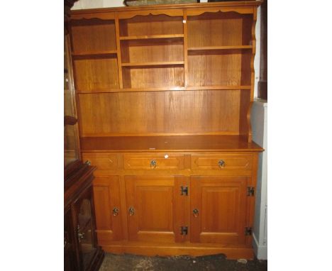 20th Century pine dresser, the boarded shelf back above three drawers and three cupboard doors on bracket feet
