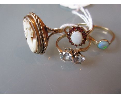 9ct Opal and garnet set flower head ring, another opal set ring, paste set crossover ring and a 9ct gold cameo set ring