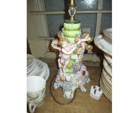 19th Century Continental porcelain lamp base mounted with figures of cherubs, floral encrusted (a/f)