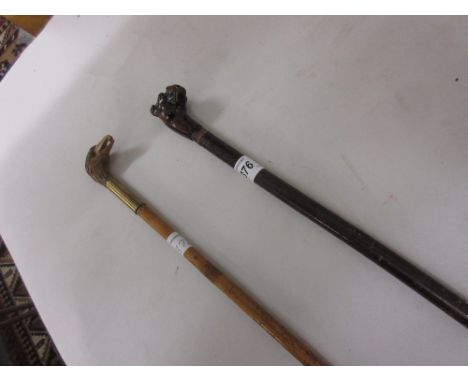 Walking stick with carved hardwood dog's head handle together with another with carved boxwood bird's head handle