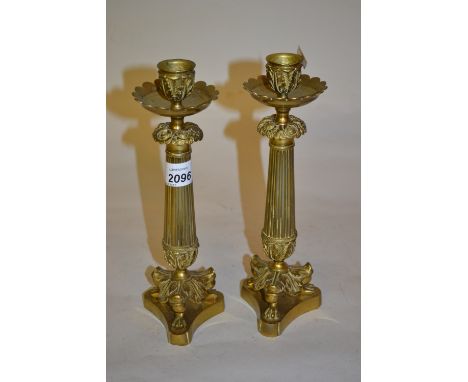 Pair of Regency style gilt brass candlesticks with acanthus sconces, fluted columns and tripod bases
