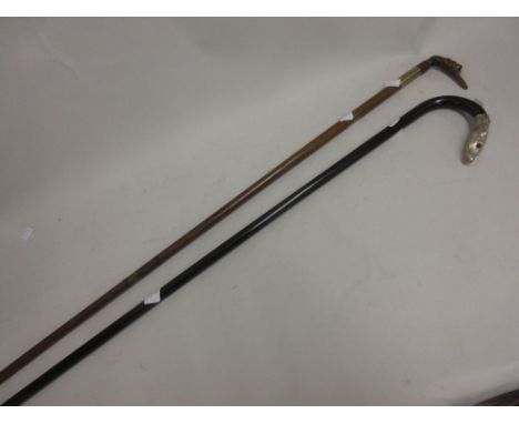 Walking stick with white metal dog's head handle together with another with carved horn bird's head handle