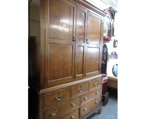 George III oak bacon cupboard, the moulded cornice above a pair of rectangular panel doors, the base with three dummy drawers