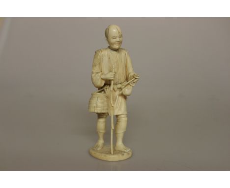 A JAPANESE IVORY SECTIONAL OKIMONO, MEIJI MERIOD, modelled as a man carrying a basket and holding a pipe, signed. 22.5cm