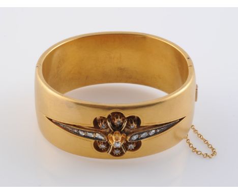 AN EARLY 19TH CENTURY DIAMOND SET BANGLE, set to the centre with a cut-out scalloped floral detail mount set with fifteen gra