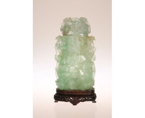 A CARVED JADE VASE AND COVER, of flattened cylindrical form, decorated in relief with birds amidst flowering boughs, mounted 