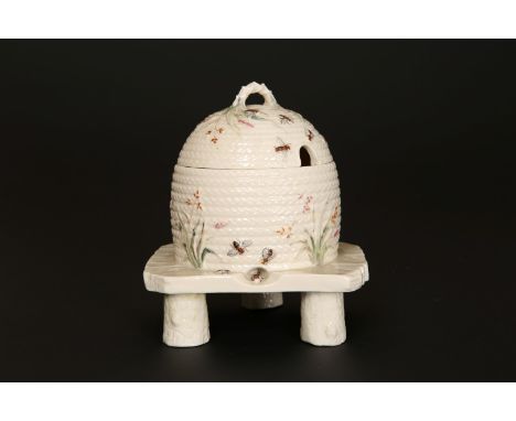 A FIRST PERIOD BELLEEK GRASS PATTERN HONEY POT AND COVER, in the form of a wicker skep on stand, black printed factory mark f