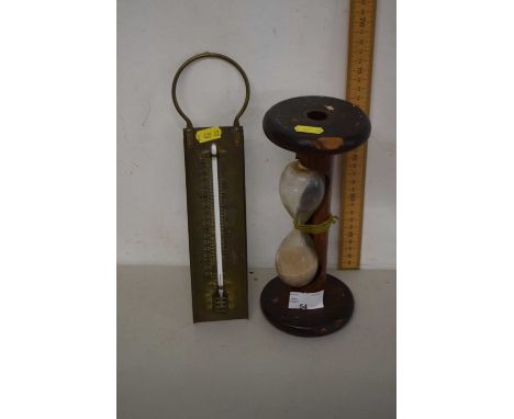 A vintage sand timer together with a vintage brass cookery thermometer