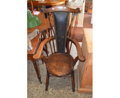 A late 19th Century oak stick back carver chair with upholstered centre