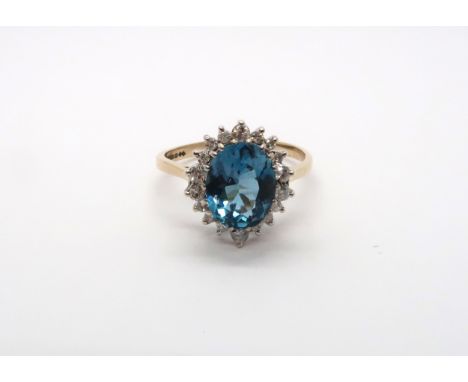 A 9ct yellow gold blue topaz and diamond ring, topaz is a good colour, diamonds bright and lively, head size approx 15mm x 13