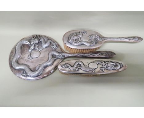 A hand mirror, hairbrush, clothes brush - all in Chinese silver decorated with dragons 