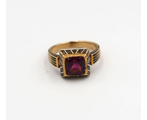 A garnet and enamel ring believed to be 19th century. Tested gold 18ct. Weight 6.47 grams. Ring size L. Good to fair conditio