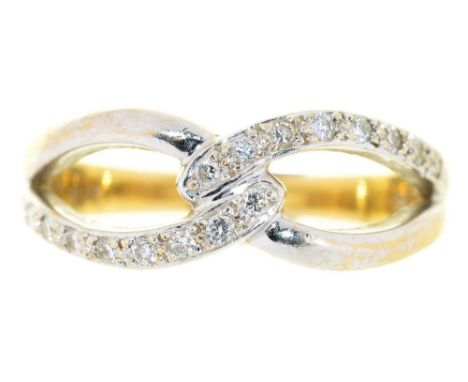 A DIAMOND CROSSOVER RING, IN TWO COLOUR GOLD, MARKED 750, 3.5G, SIZE O++GOOD CONDITION WITH LIGHT WEAR AND SCRATCHES CONSISTE