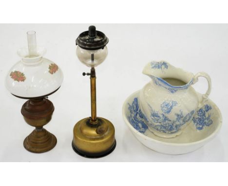 AN EARLY 20TH C BRASS OIL LAMP WITH ENAMELLED GLASS SHADE, PARAFFIN LAMP AND A BLUE AND WHITE EARTHENWARE CHAMBER SET 