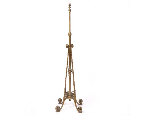 A VICTORIAN CAST BRASS HEIGHT ADJUSTABLE LAMP STANDARD converted for electric use with four scrolling feet, 173cm high