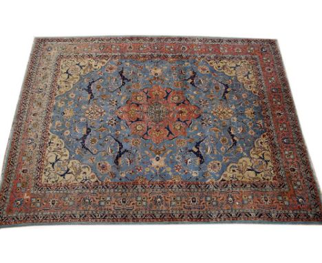 A PERSIAN BLUE AND RED GROUND CARPET with stylised foliate decoration and multiple banded border, 323cm x 444cm 