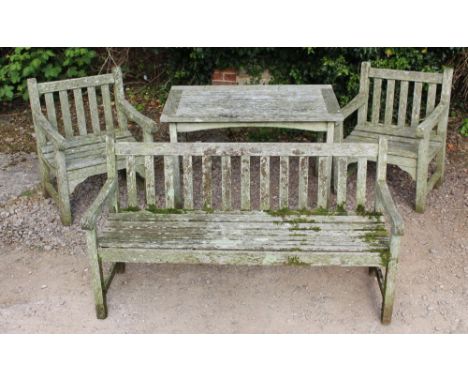 A TEAK GARDEN BENCH with slatted back and seat together with two matching arm chairs and a table, the bench 152.5cm wide, the