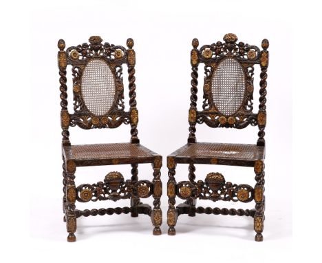 A PAIR OF CROMWELLIAN STYLE CARVED AND PARCEL GILT SIDE CHAIRS the cresting rails with vases of flowers flanked by cherubs, w