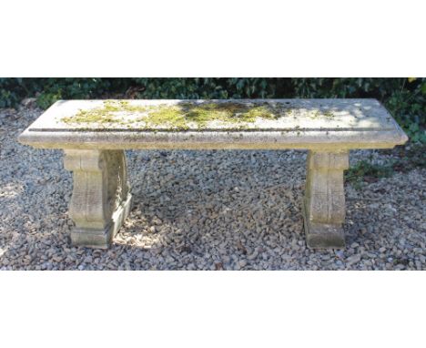 A RECTANGULAR CONCRETE GARDEN BENCH OR SEAT on scrolled and fluting vine decorated supports, 130cm wide