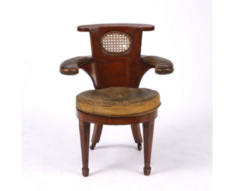 A 19TH CENTURY MAHOGANY COCK FIGHTING ARMCHAIR with arching back and oval caned back and seat, leather upholstered arms and l