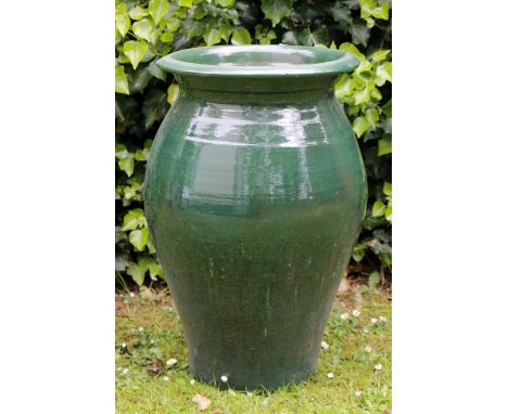 A GREEN GLAZED POTTERY BALUSTER PLANTER with flared rim, 59cm high