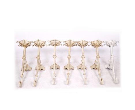 A GROUP OF SIX CREAM PAINTED WALL LIGHTS in the form of torcheres, each with scrolling brackets, approximately 70cm high toge