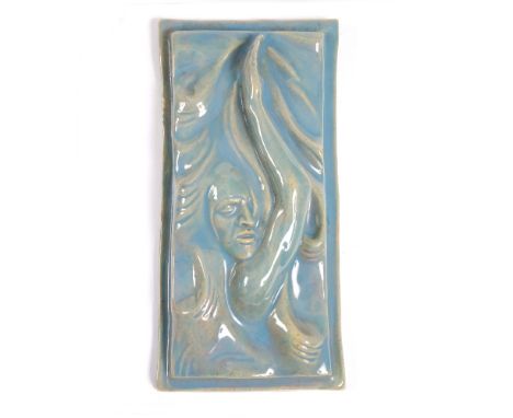 A SMALL STUDIO POTTERY TILE depicting a swimmer with over painted blue glaze incised to the reverse with initials 'E.P' indis