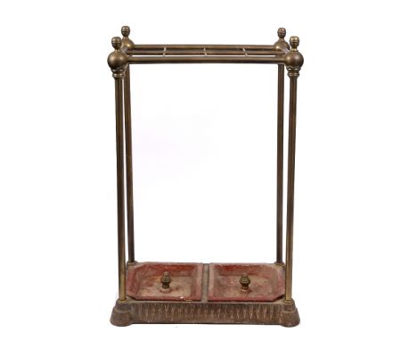 A VICTORIAN BRASS STICK STAND with cast base and red painted cast iron inset trays, the top with segmented section between th