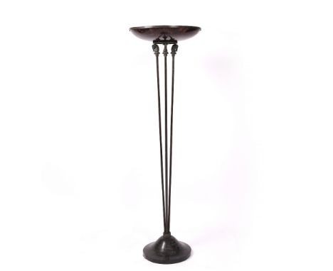 A FLOOR STANDING LAMP with spreading faux tortoiseshell shade on a support surmounted by cast horses heads, on a circular spr
