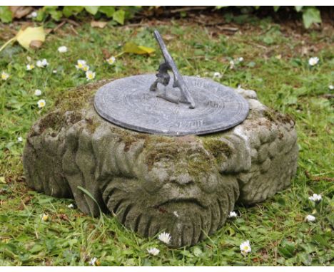 A SQUARE WEATHERED STONE SUNDIAL PLINTH 45cm square with hand carvings to side and carved faces to each corner, together with