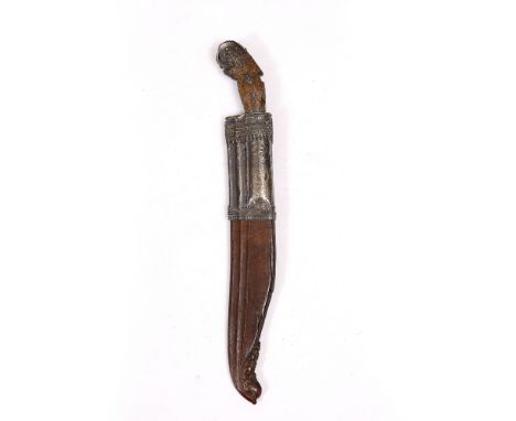 A CINGALESE KNIFE AND SCABBARD  with white metal mounted steel blade and carved horn grip, the carved wooden scabbard with wh