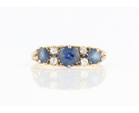 A sapphire and diamond ring, set with three principal round cut sapphires separated by old cut diamond accents, stamped 18ct,