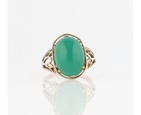 A green hardstone cabochon ring, with open metalwork shoulders, indistinctly marked, ring size R.