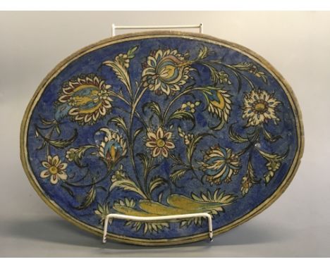 An oval tile with Persian floral design, 31cm x 39cm.