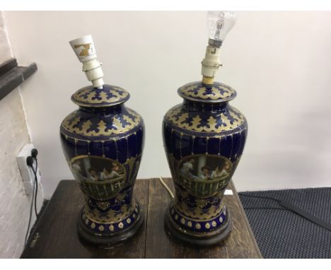 A pair of blue and gilt lamp bases depicting females.