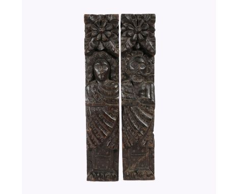One male, the other female, each with one arm folded beneath a sash, topped by a large leafy-flowerhead, pedestal base, with 