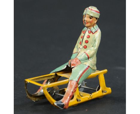 38. MEIER BOY ON SLED PENNY TOY | Provenance: Paul Cole Collection. | 2.5" l. | (Very Good Condition) | $300 - $400