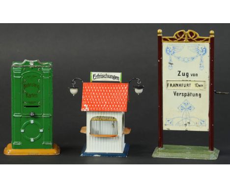 573. THREE BING TRAIN ACCESSORIES | Hand painted ticket dispenser, refreshment stand, and train delay indicator board featuri