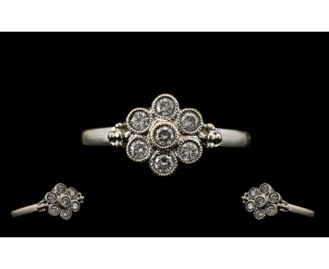 18ct White Gold Attractive Diamond Set Cluster Ring.  Paver set, flowerhead design.  Marked for 18ct.  The seven diamonds of 