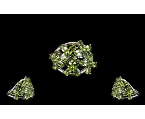 Peridot Flower Cluster Ring, an openwork floral cluster mount set with oval cut peridots of 4.75cts, curving closely to the f