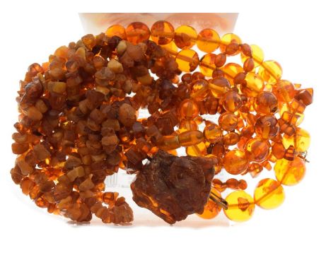 Long string of tumbled and amber beads approximately 196cm long, together with a natural amber boulder as bar brooch, graduat