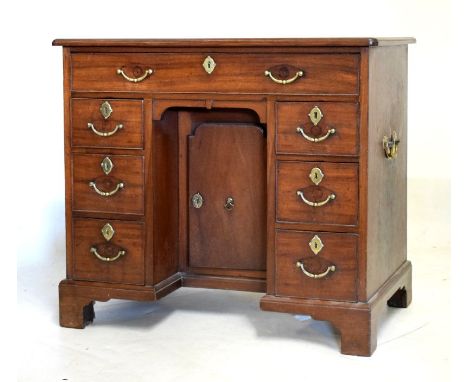 George III mahogany kneehole desk fitted one long drawer above a kneehole cupboard door flanked each side by three drawers on