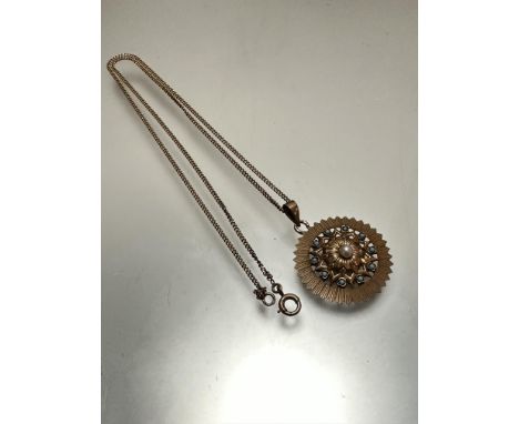 A yellow metal circular open-work pendant, set central cultured pearl with surround of ten turquoise small cabochon's, mark o
