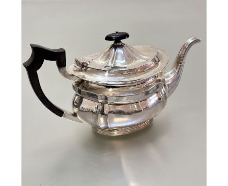 A Sheffield silver panelled teapot of oval form, raised on oval fluted base, (h15cm x 28cm including handle and spout x 12cm)